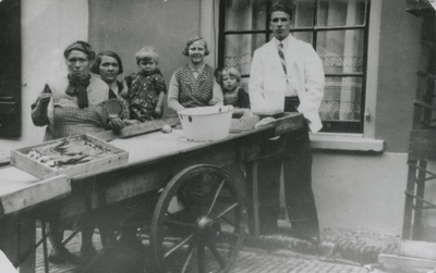 875391 Afbeelding van een groepje Wijk C-bewoners bij de viskar van 'opoe van den Berg' (links), vermoedelijk uit de ...